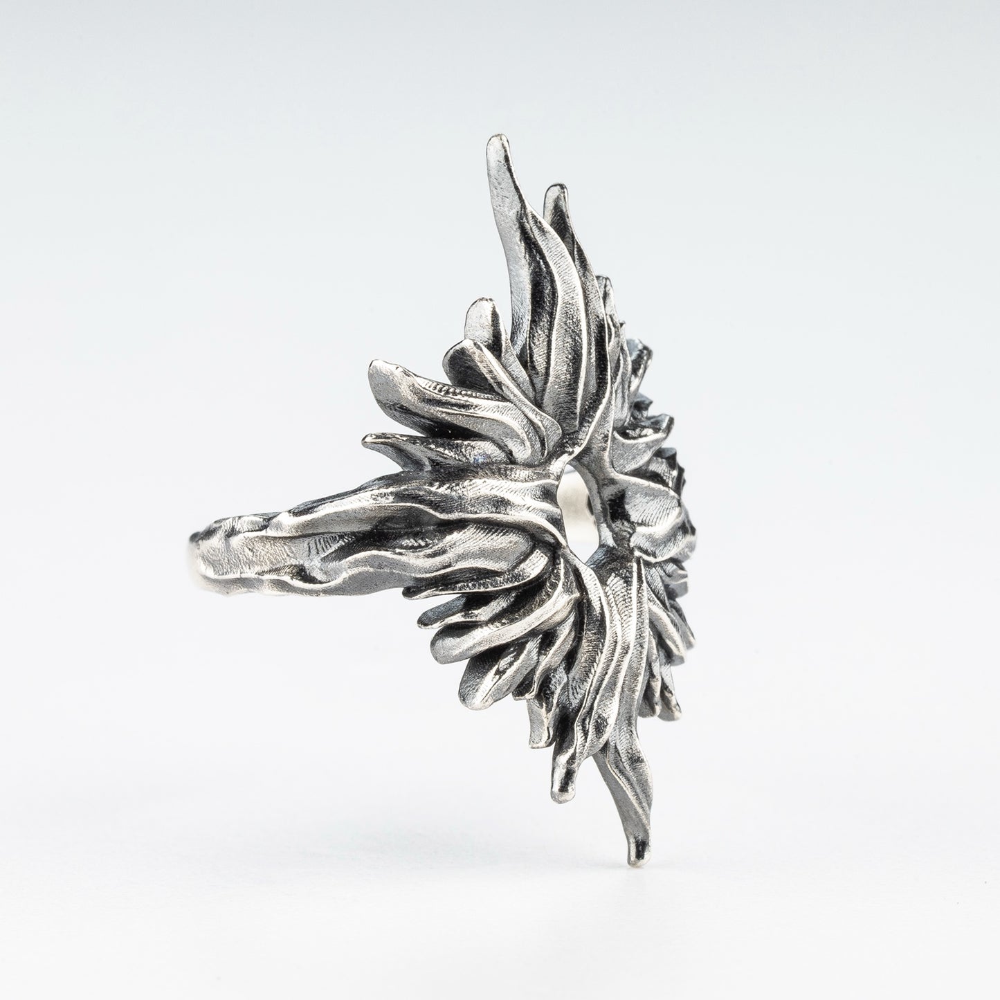 Profile view of sculptural gothic sun ring in silver