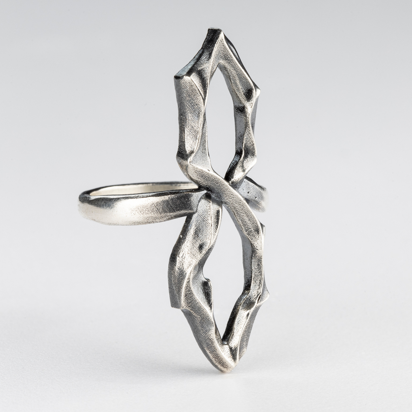 Handcrafted gothic silver 8 ring — side view showing twisted mirrored silhouette.