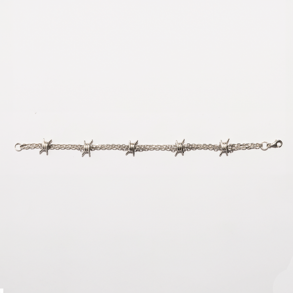 Flat view of the Barbwire Bracelet in sterling silver by Sebamakes, showing handcrafted barbed wire details and clean industrial lines.