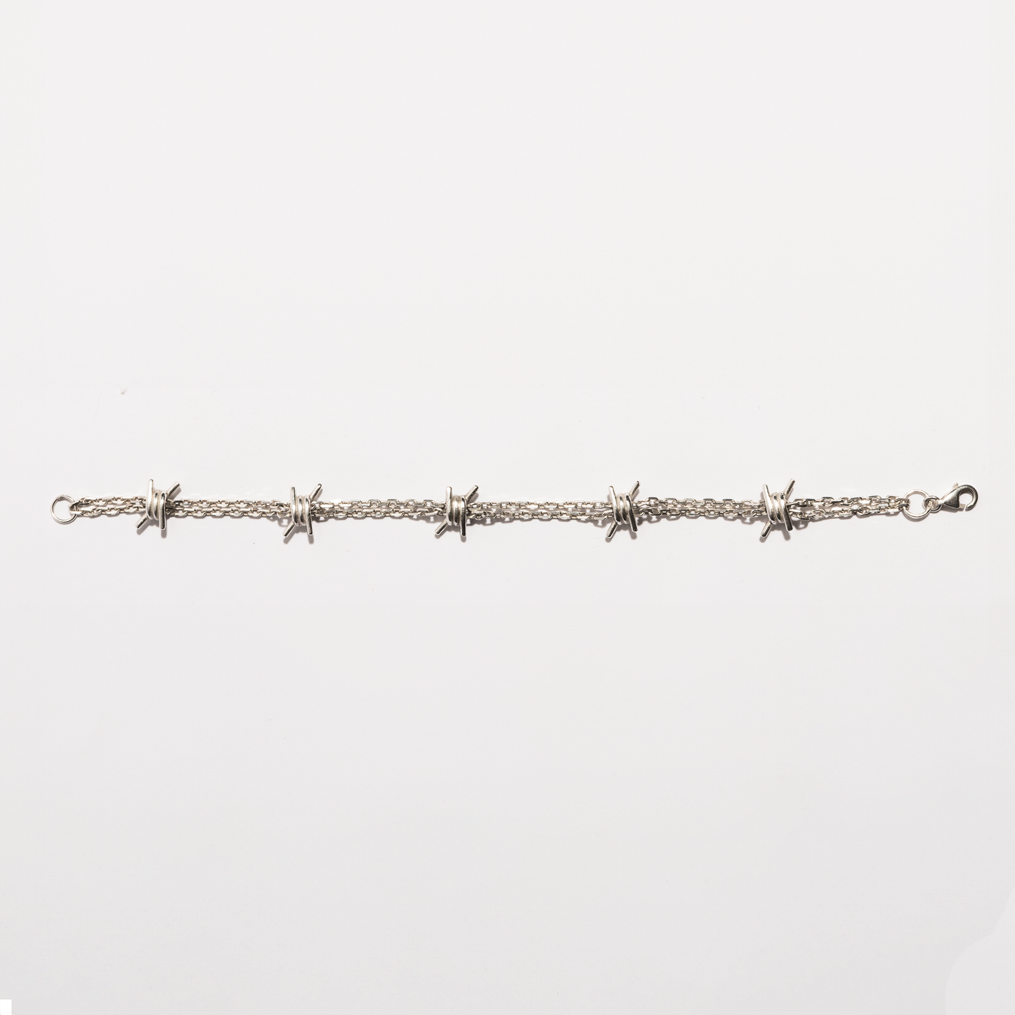 Flat view of the Barbwire Bracelet in sterling silver by Sebamakes, showing handcrafted barbed wire details and clean industrial lines.