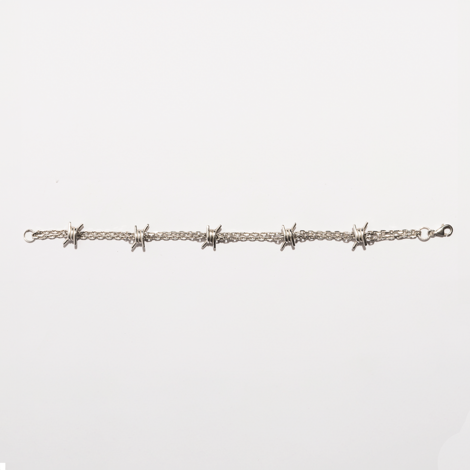 Flat view of the Barbwire Bracelet in sterling silver by Sebamakes, showing handcrafted barbed wire details and clean industrial lines.