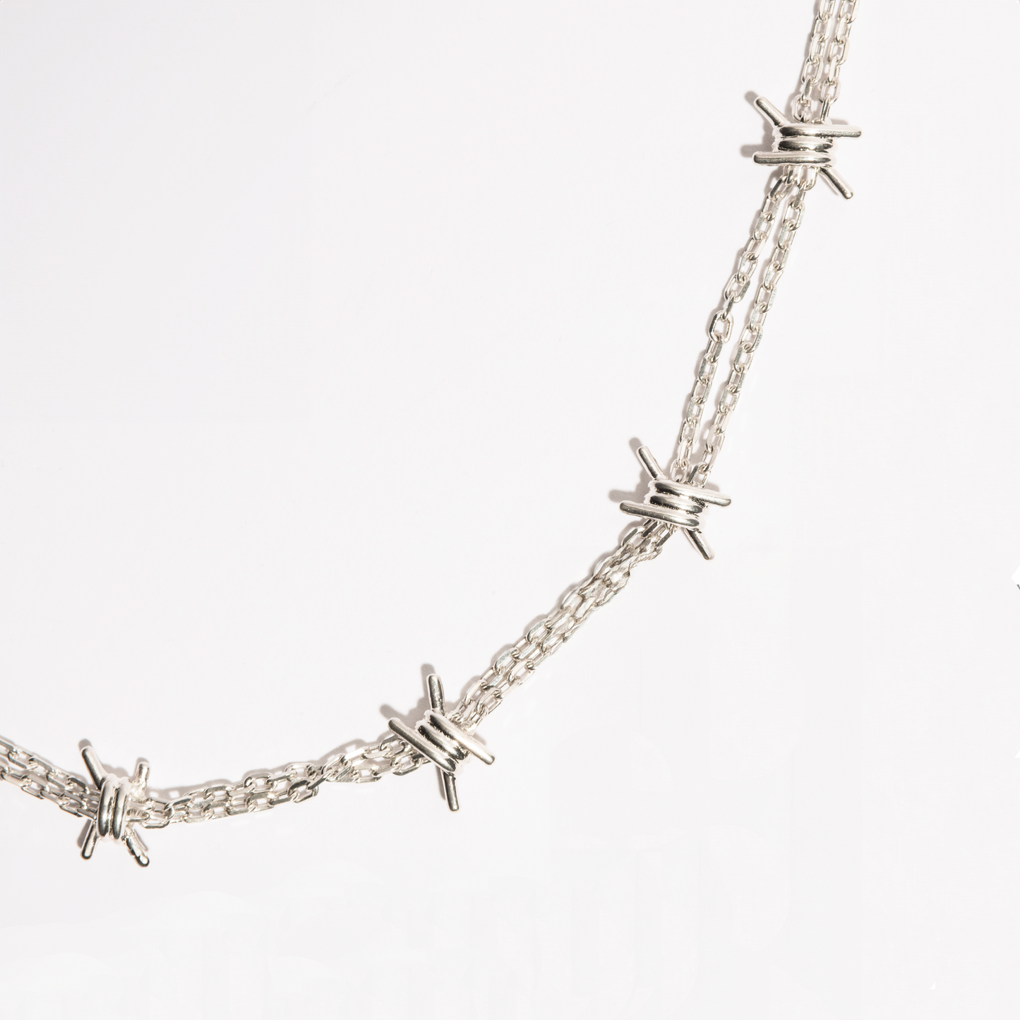Detail view of the Barbwire Necklace in sterling silver by Sebamakes, showing handcrafted barbed wire spikes and sculptural metallic texture.