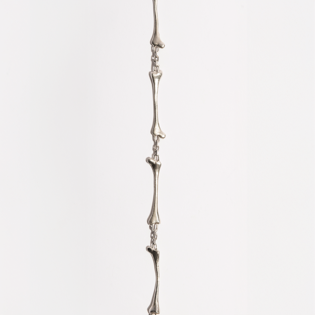 Flat view of the Bone Bracelet in sterling silver by Sebamakes, showing detailed handcrafted bone links inspired by human skeletal forms.