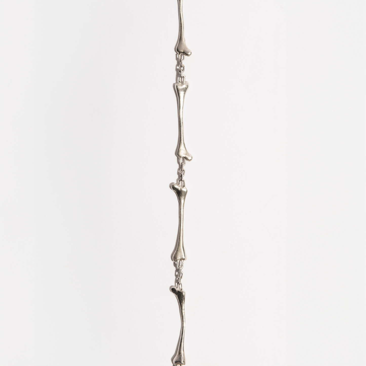 Flat view of the Bone Bracelet in sterling silver by Sebamakes, showing detailed handcrafted bone links inspired by human skeletal forms.