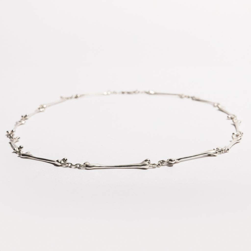 Full view of the Bone Necklace in sterling silver, handcrafted by Sebamakes with interconnected bone-like elements, made in Italy.