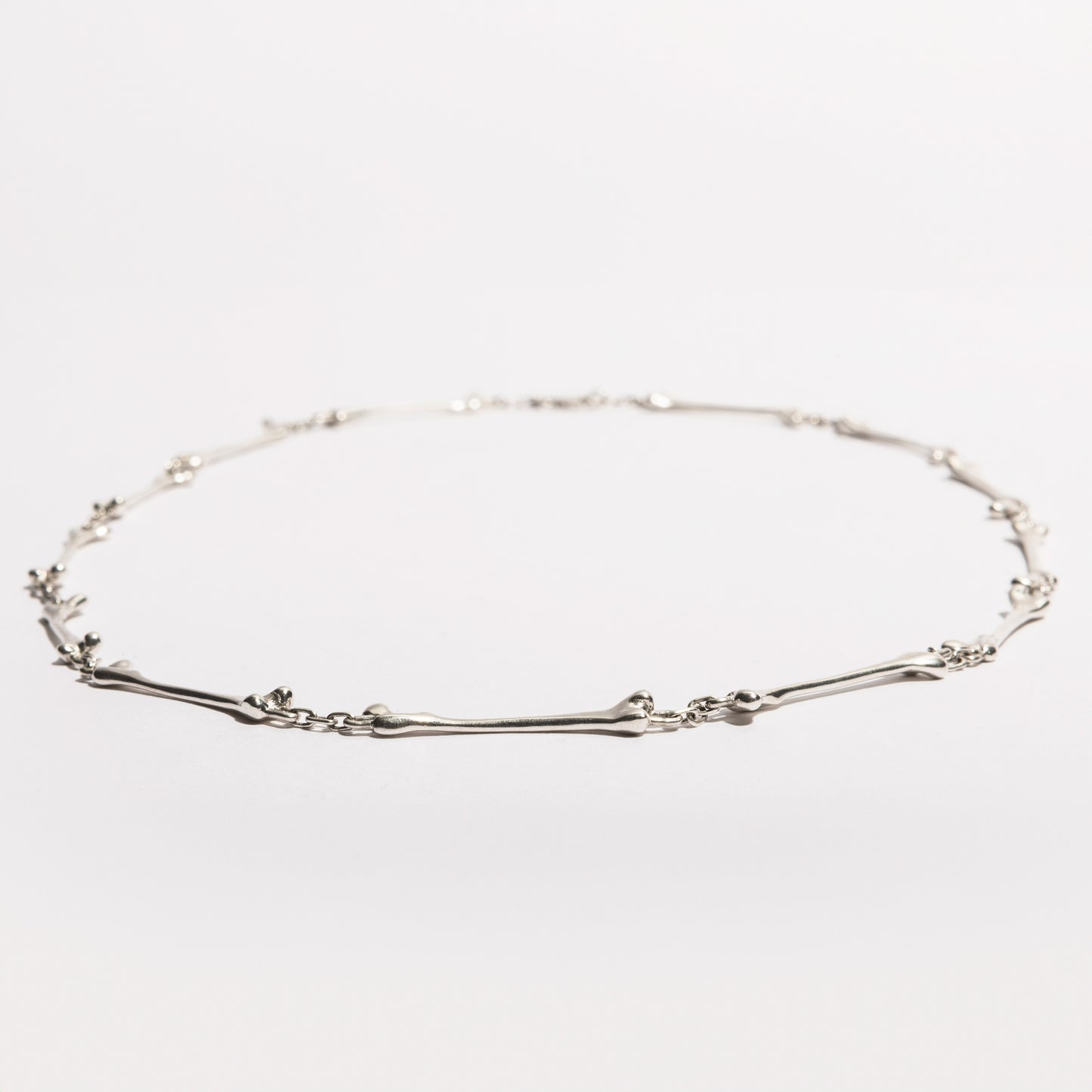 Full view of the Bone Necklace in sterling silver, handcrafted by Sebamakes with interconnected bone-like elements, made in Italy.
