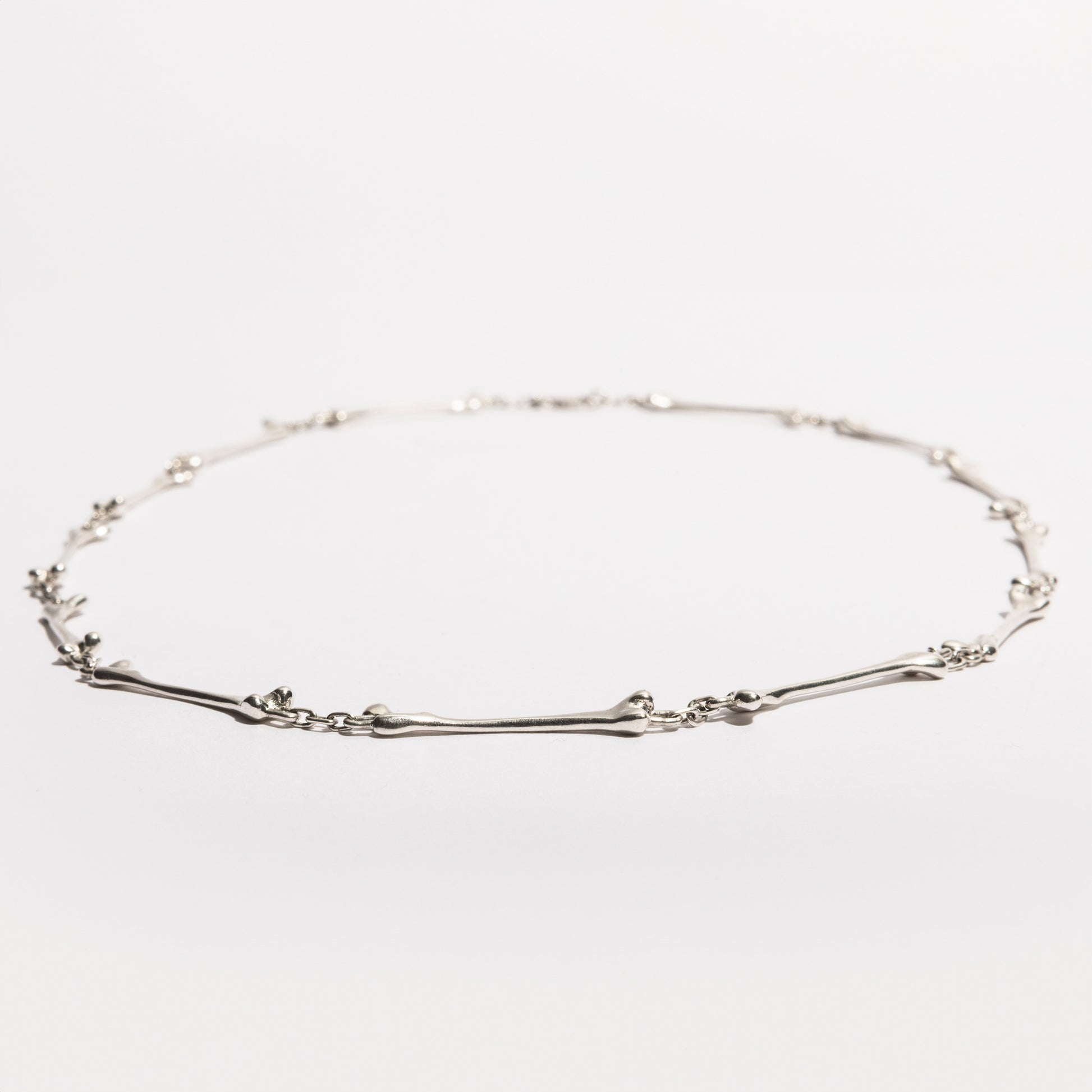 Full view of the Bone Necklace in sterling silver, handcrafted by Sebamakes with interconnected bone-like elements, made in Italy.