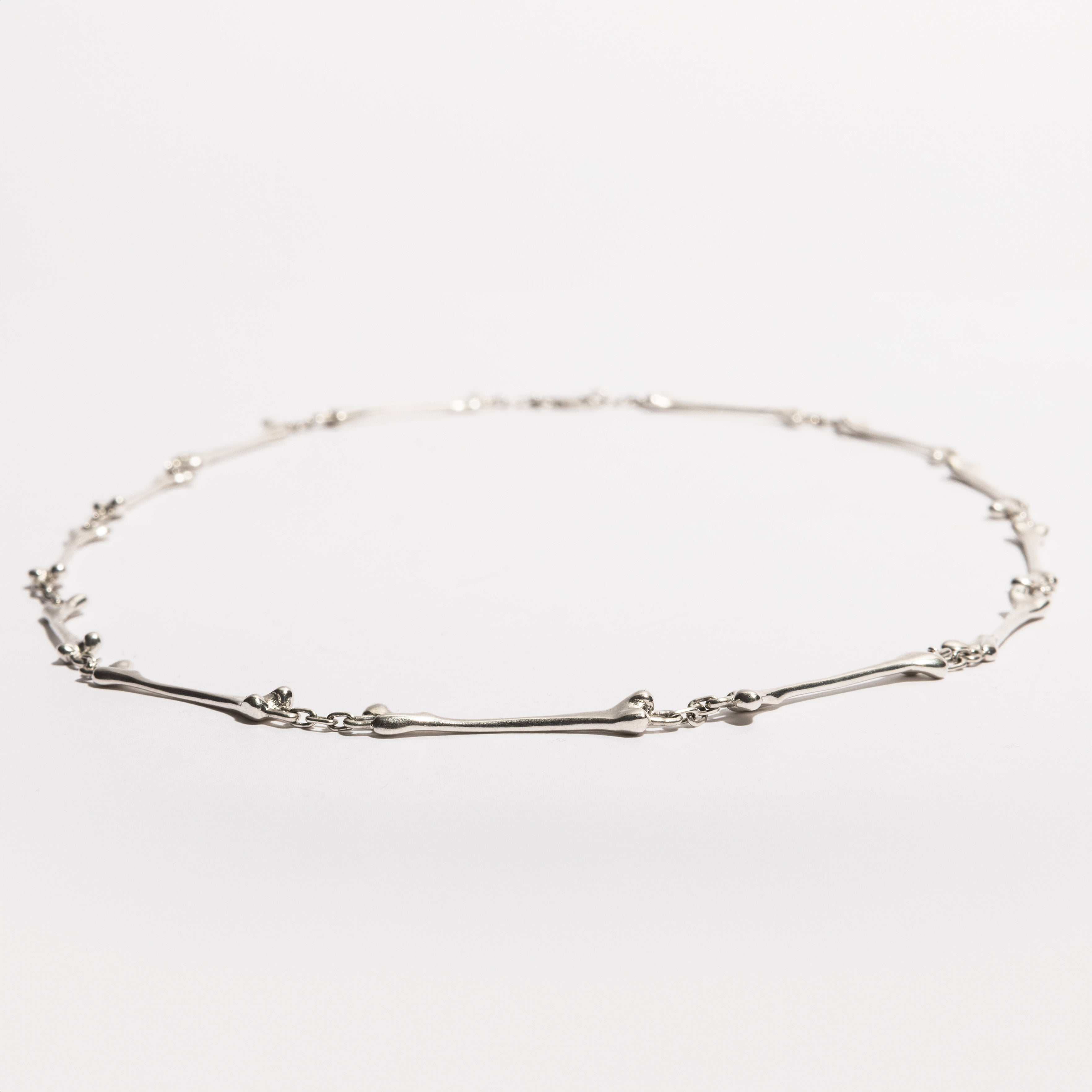 Full view of the Bone Necklace in sterling silver, handcrafted by Sebamakes with interconnected bone-like elements, made in Italy.