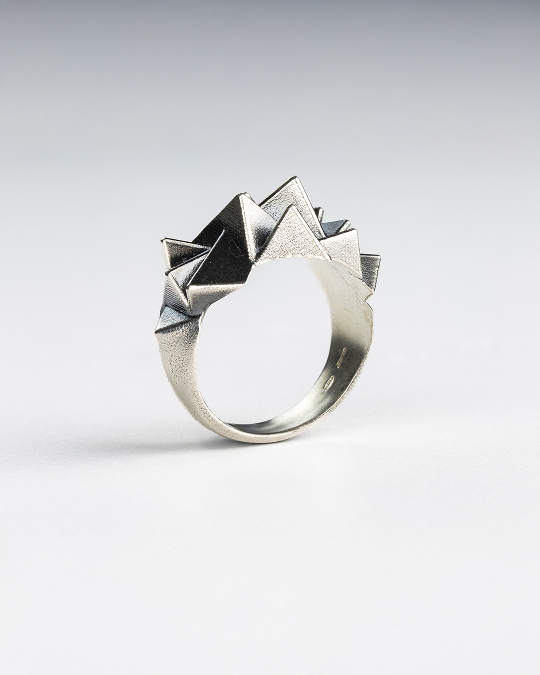 Side profile of the sterling silver Cestia Ring showing its sculptural volume and vertical tension.