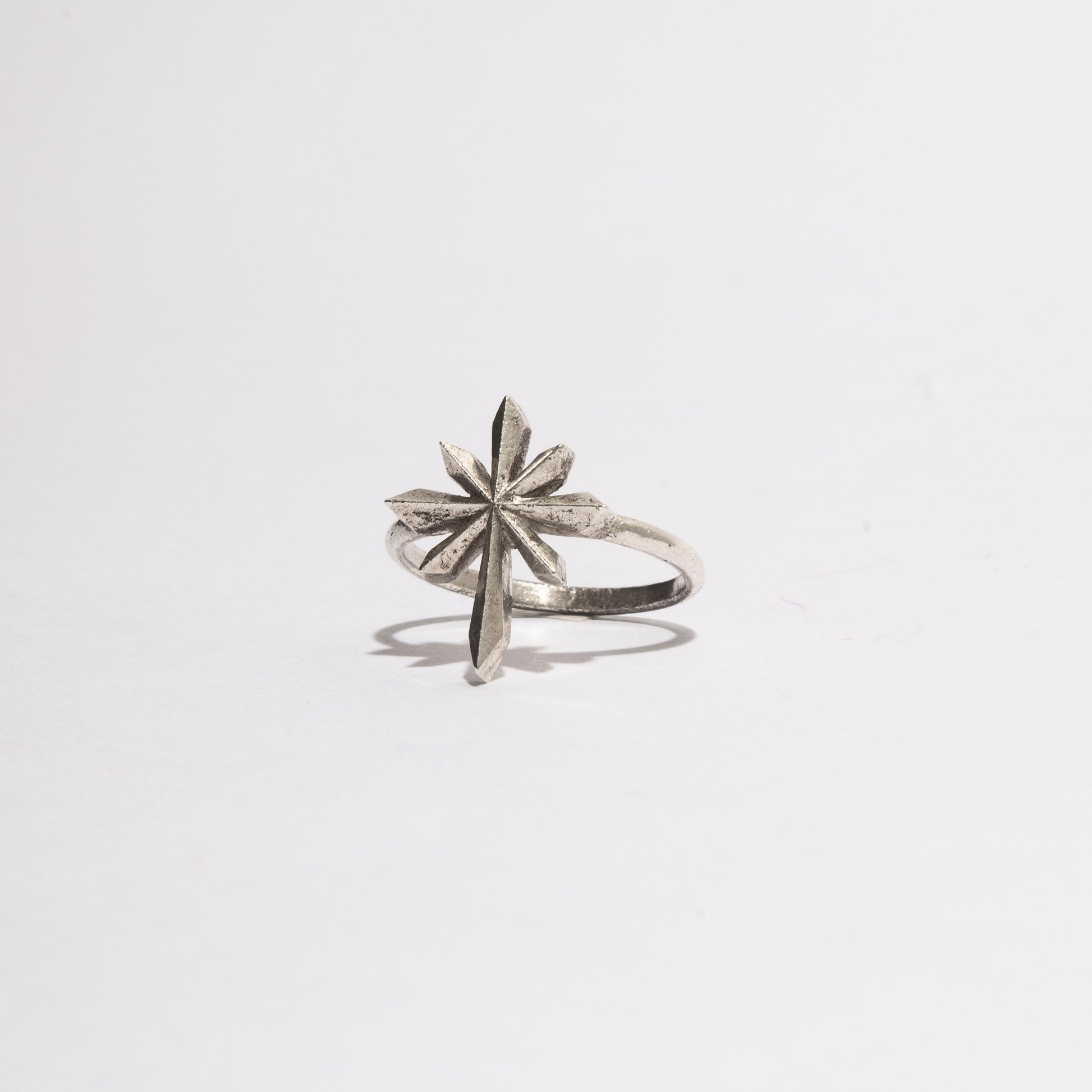 Angled view of the Comet Ring in sterling silver by Sebamakes, showcasing its sculptural geometric form with a directional structure inspired by a comet.