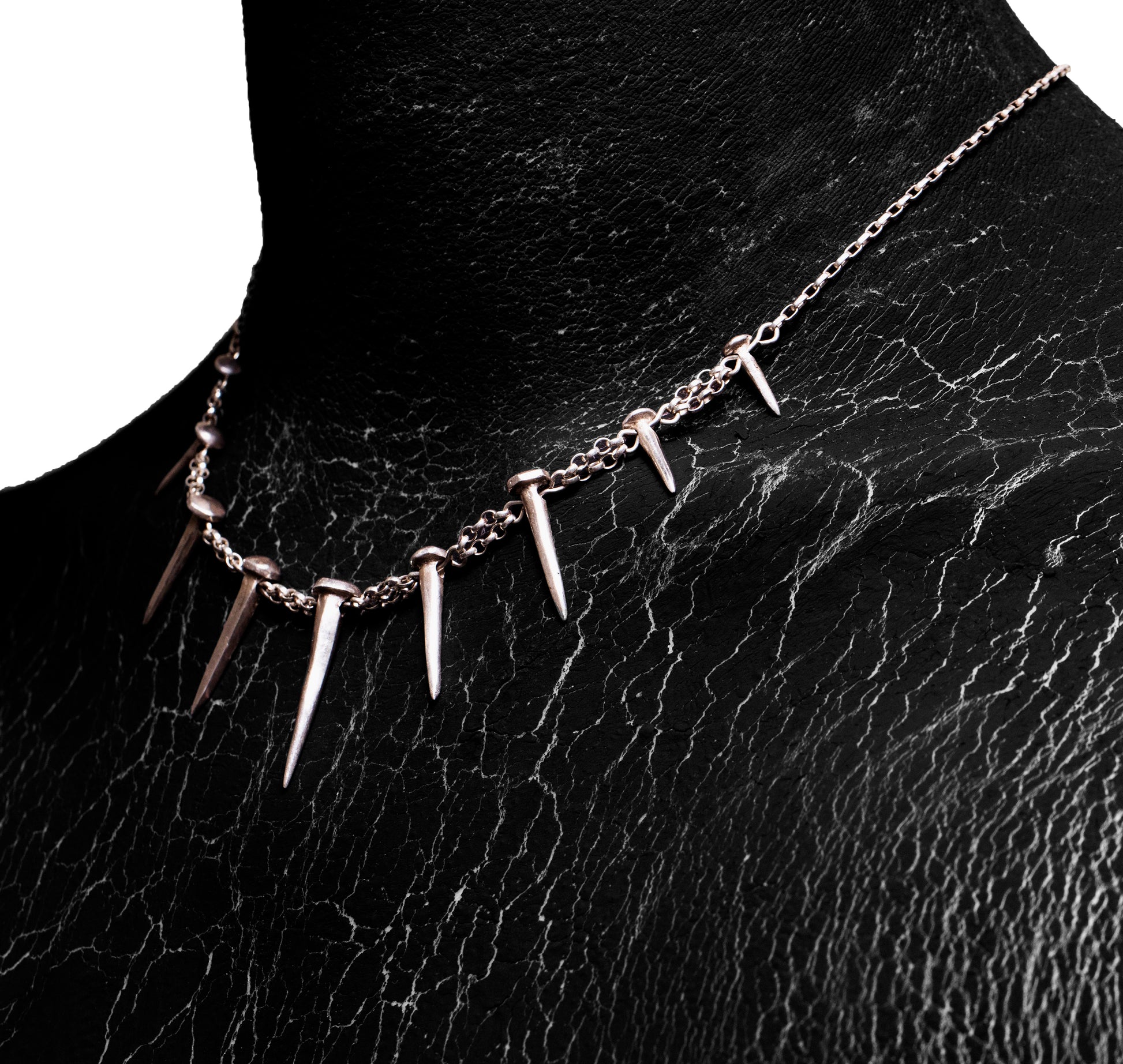 Angled worn view of the Nails Necklace by Sebamakes, sterling silver handcrafted necklace with nail-shaped spikes and raw textured finish.