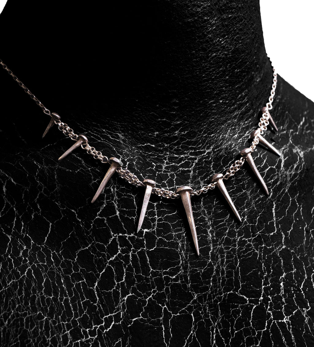 Close-up worn view of the Nails Necklace by Sebamakes, handcrafted sterling silver statement necklace inspired by industrial spikes and minimalist sculpture.