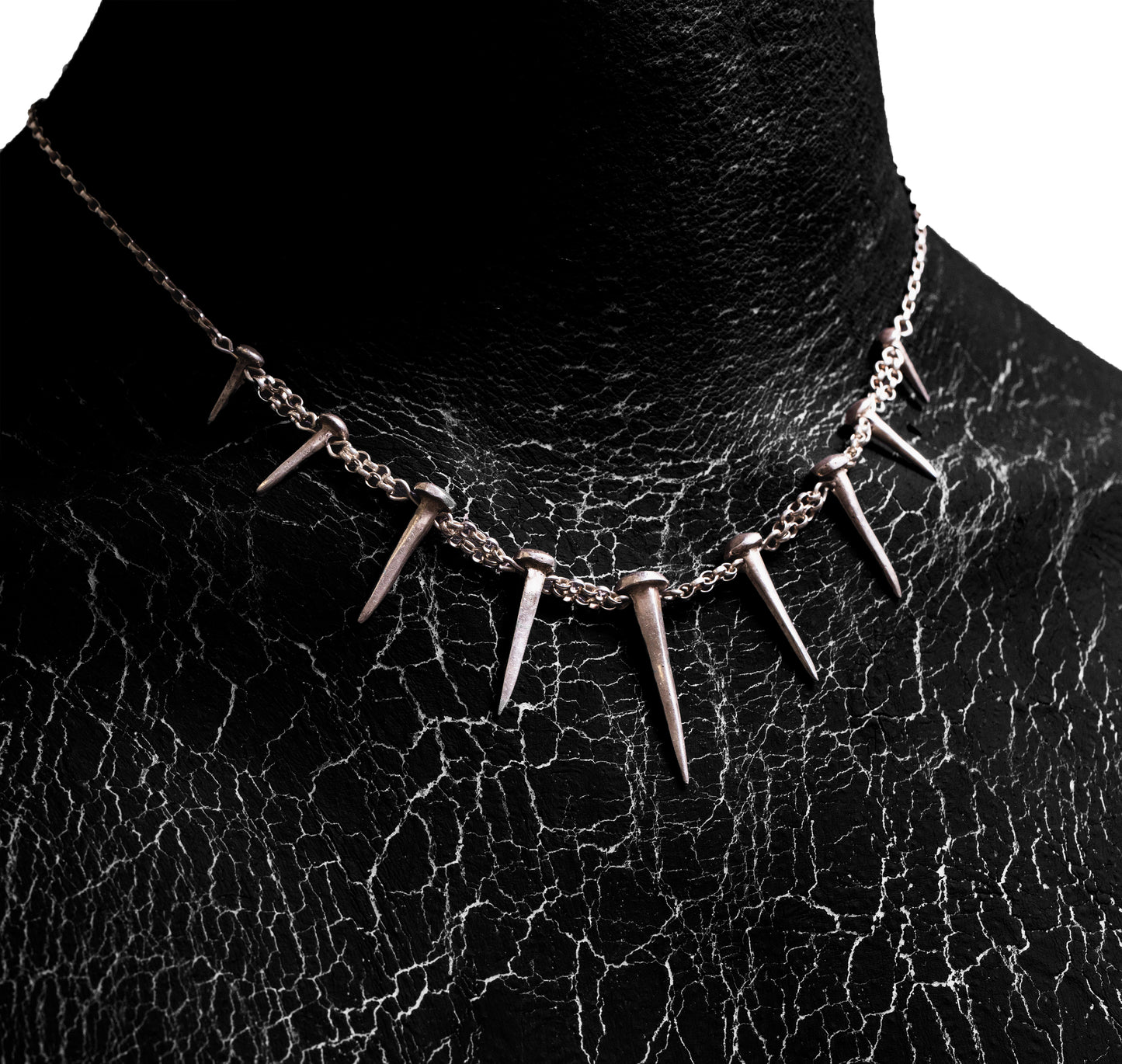 Close-up worn view of the Nails Necklace by Sebamakes, handcrafted sterling silver statement necklace inspired by industrial spikes and minimalist sculpture.