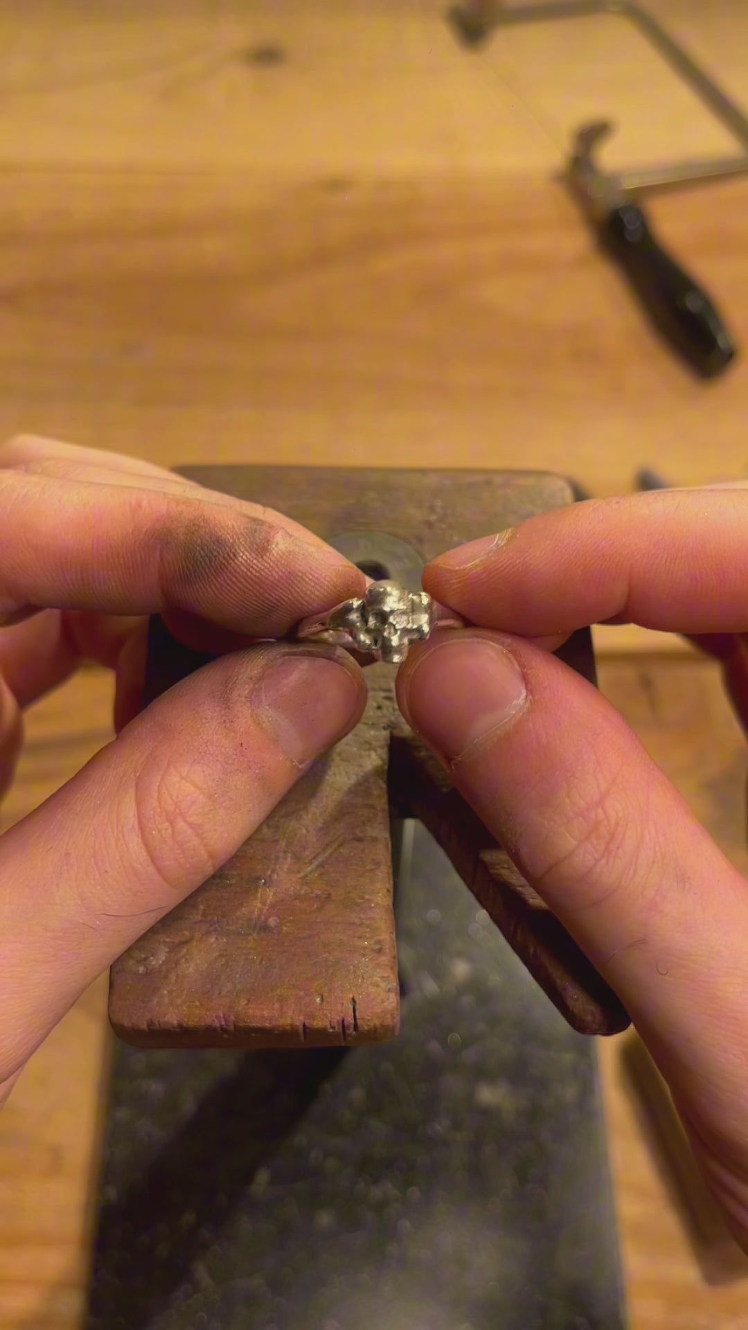 Demonstration video showing the handcrafted silver Skull Ring by Seba Makes held at the jeweler's workbench, highlighting its proportions and artisanal finish.
