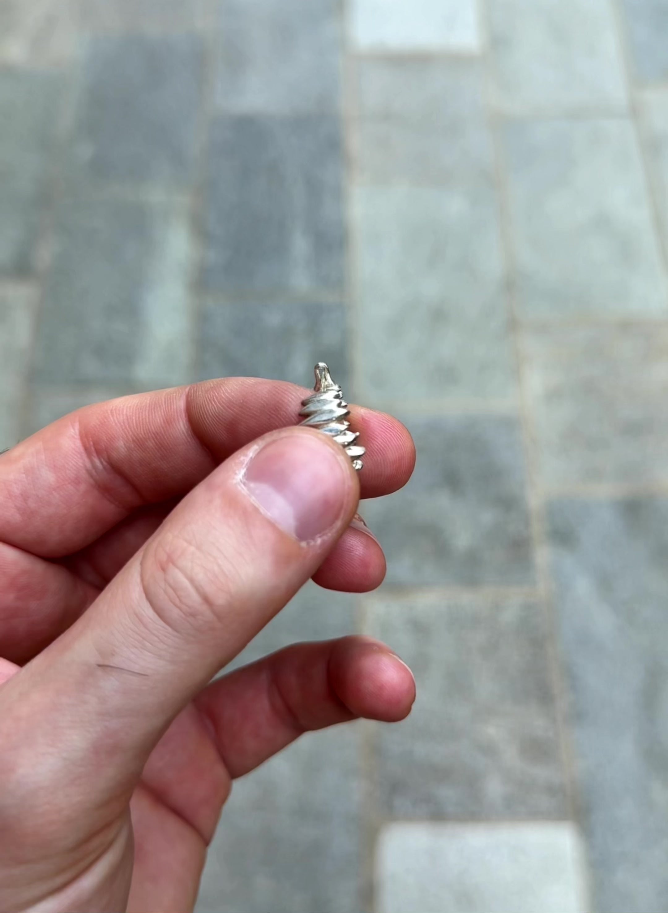 Splinters hoop earrings held in hand to showcase artisanal proportions.