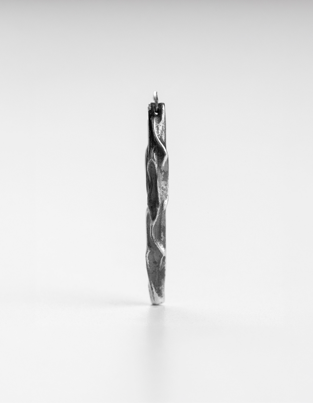 Slim vertical profile view of the handcrafted long silver Ridge drop earrings.