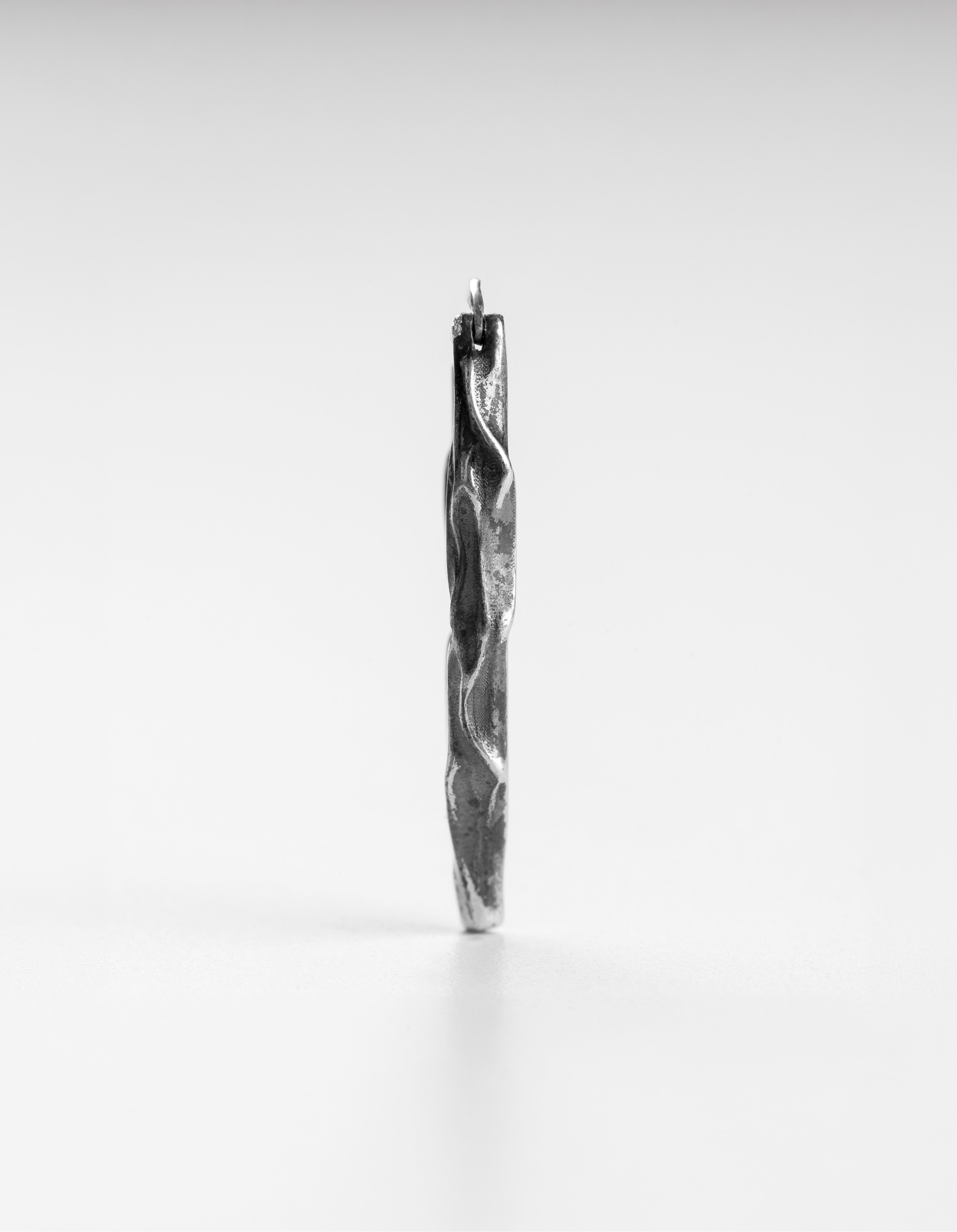 Slim vertical profile view of the handcrafted long silver Ridge drop earrings.