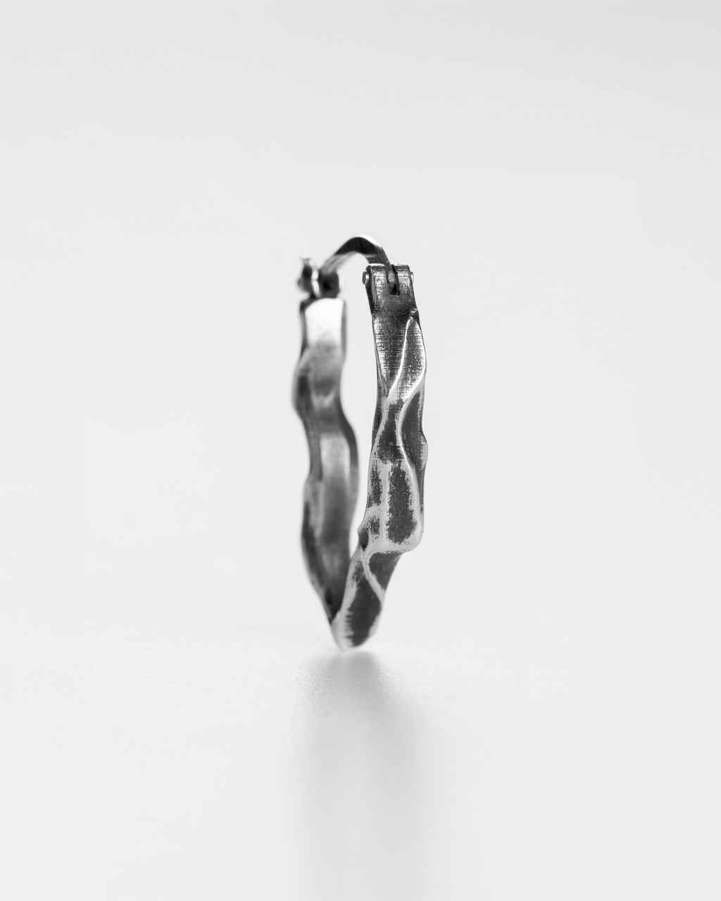 Profile and thickness view of the handcrafted compact silver Ridge hoop earrings.