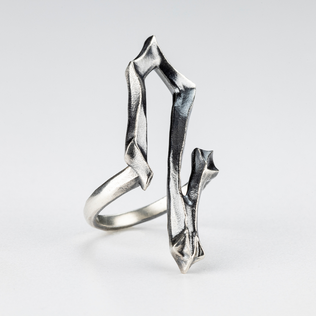 Close-up of the 2 Ring showing the brutalist carved details and silver surface