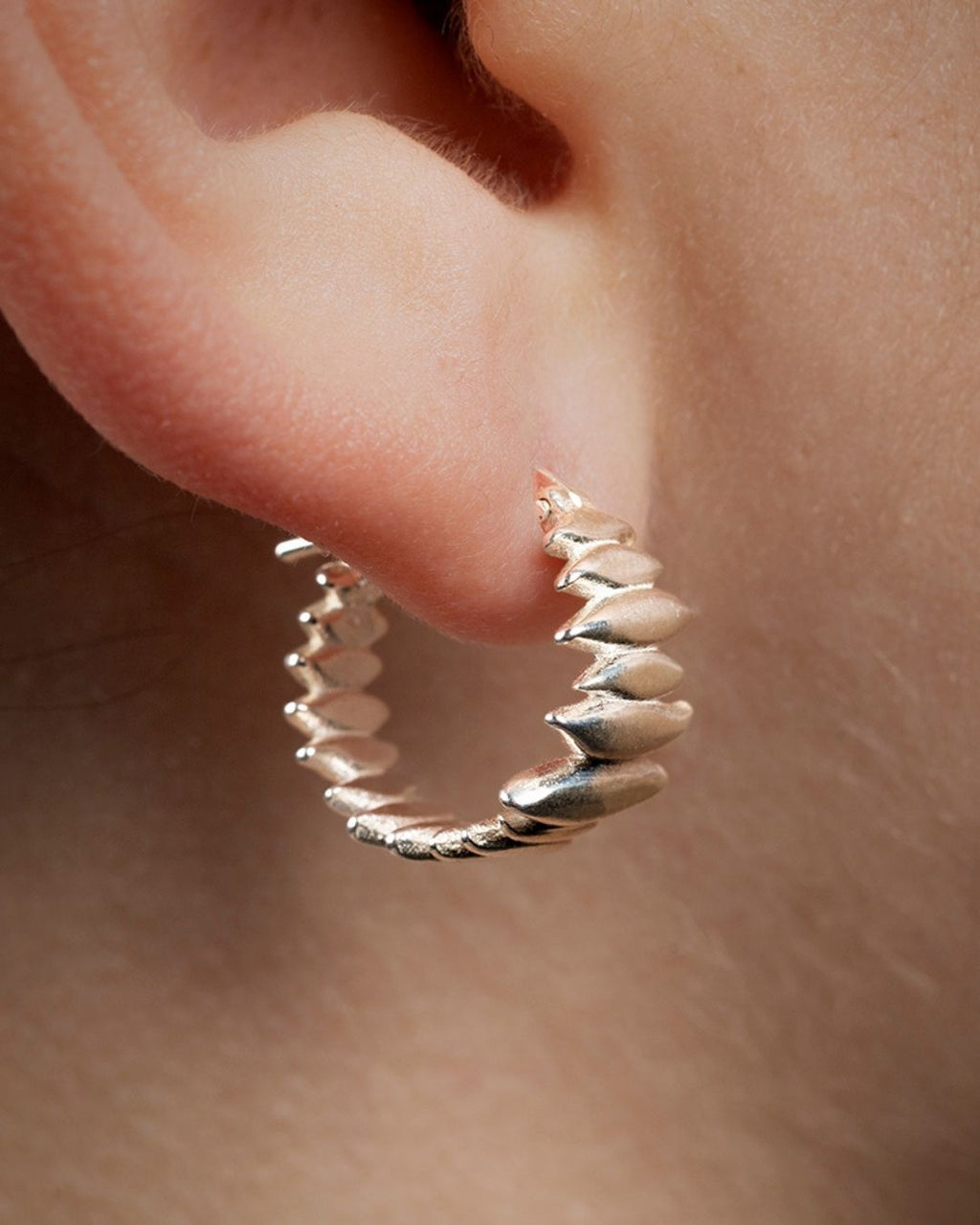 Splinters earrings worn on the earlobe, showing the fit and scale.