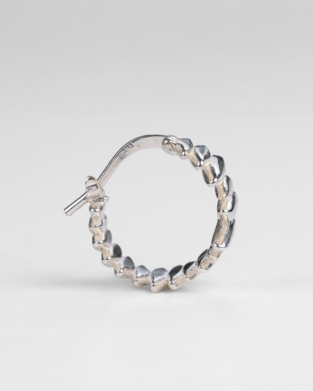  Detail view of the sculptural, fractured surface on the silver Splinters earrings.